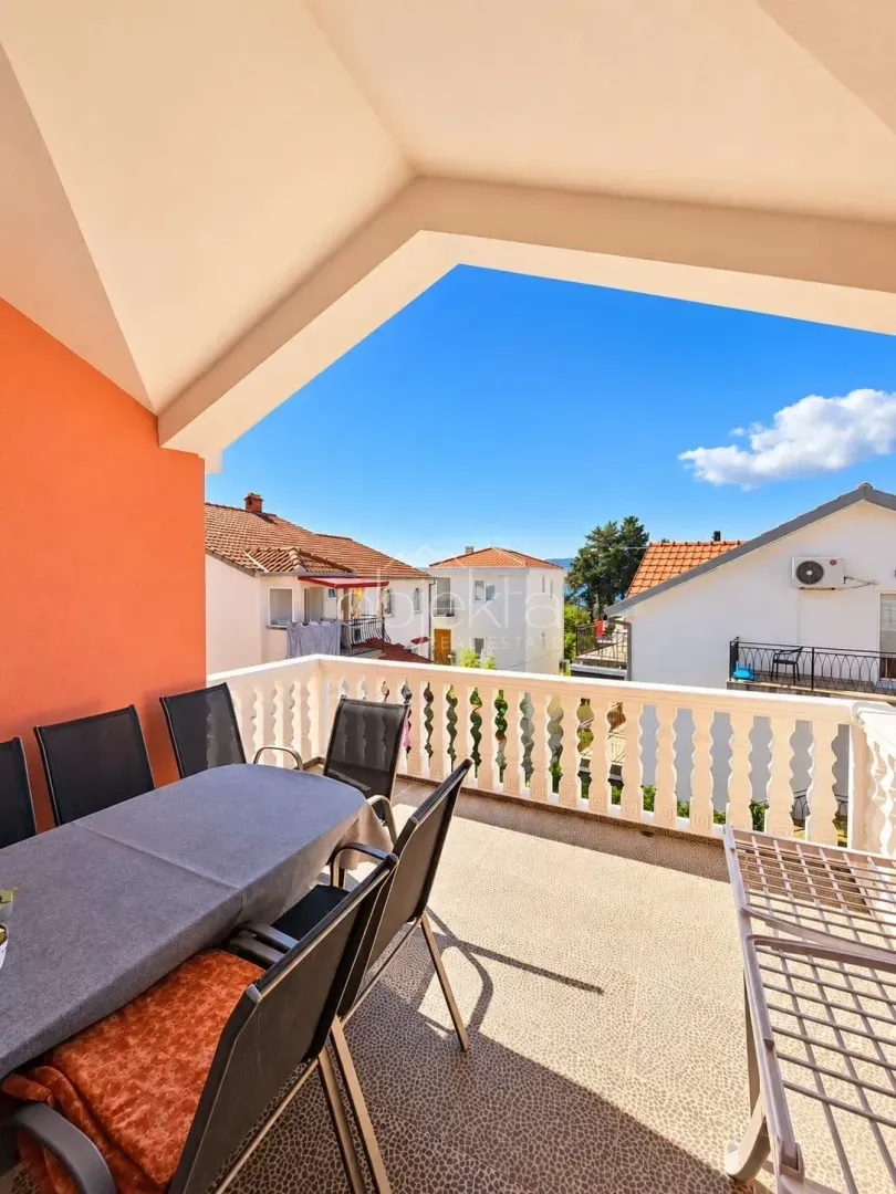 Spacious covered terrace with outdoor seating and a view of the neighborhood.