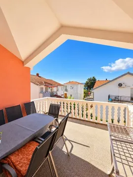 Spacious covered terrace with outdoor seating and a view of the neighborhood. - image 6