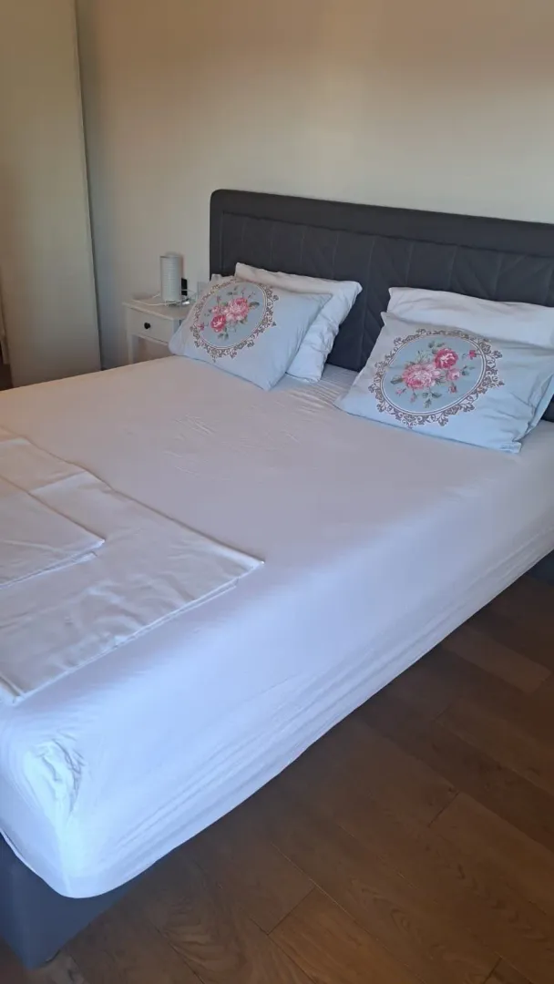 Uredna spavaća soba sa bračnim krevetom.
