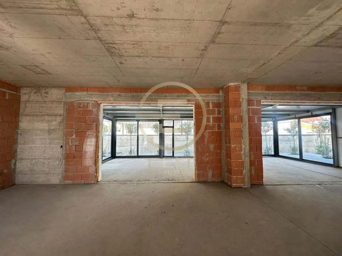 Unfinished interior under construction with concrete and brick walls.