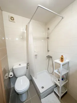 Small bathroom with a shower cabin and toilet. - image 6