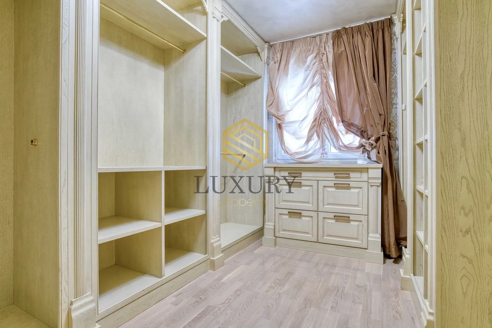 Walk-in closet with built-in wardrobes and a window.