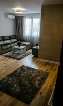 Bright living room with a leather sectional sofa and wooden flooring. - image 3