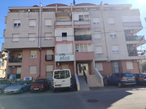 Fasada stambene zgrade sa ulazom i parkingom ispred. - image 2
