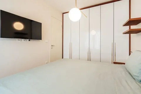 Moderna spavaća soba sa bračnim krevetom, ugradnim plakarom i televizorom na zidu. - image 7