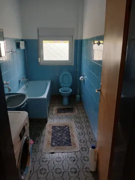 Kupatilo sa plavim pločicama, kadom i veš mašinom. - image 11