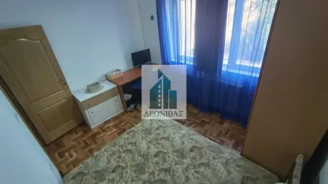 Manja spavaća soba sa krevetom, radnim stolom i prozorom sa plavim zavesama. - image 9