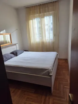 Spavaća soba sa bračnim krevetom i prozorom sa zavjesama. - image 3