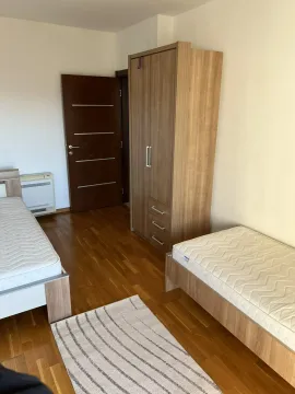 Spavaća soba sa dva singl kreveta i drvenim ormarom. - image 2