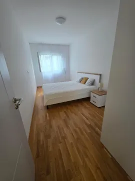 Namještena spavaća soba sa bračnim krevetom i drvenim podom. - image 5