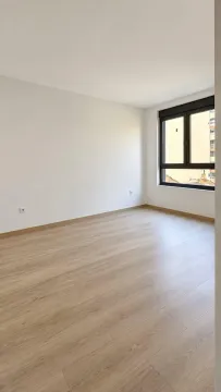 Prazna soba sa svetlim laminatom i prozorom. - image 6