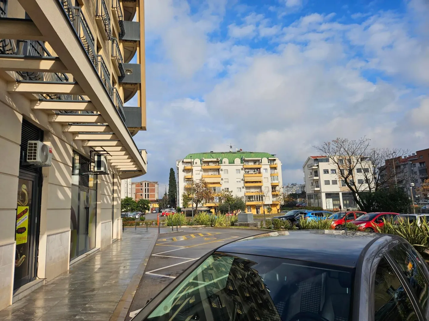Exterior of an apartment building and parking lot in front of the entrance.