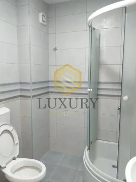 Manje kupatilo sa tuš kabinom i sanitarijama u svijetlim pločicama. - image 4