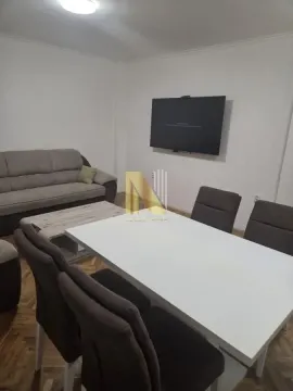 Dnevna soba sa garniturom, trpezarijskim stolom i televizorom na zidu. - image 14