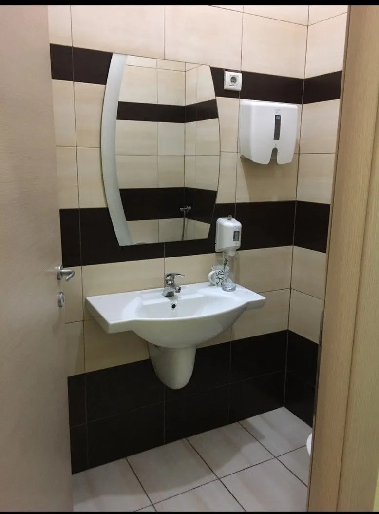 A small restroom with a sink and a mirror.