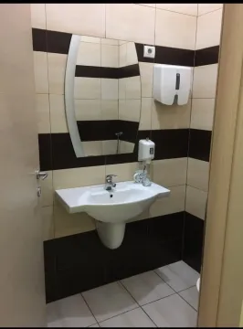 A small restroom with a sink and a mirror. - image 2