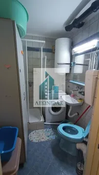 Bathroom equipped with a shower cabin, washbasin, toilet, and washing machine. - image 11