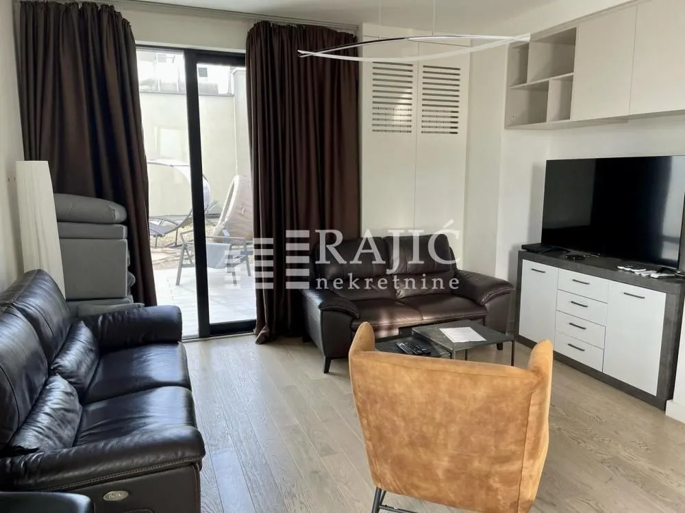 Furnished living room with sofa set and TV.