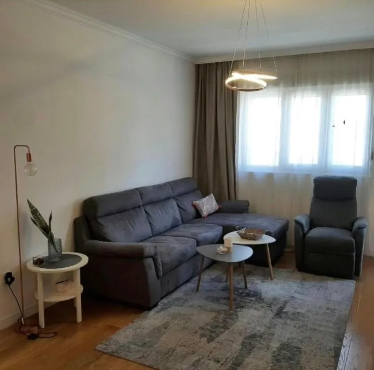 Furnished living room with a sectional sofa, armchair, and modern lighting.