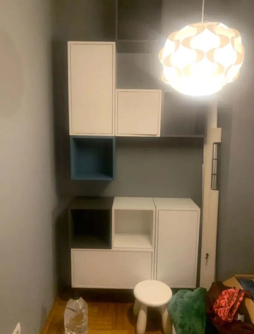 Small space with built-in storage units and a hanging lamp.