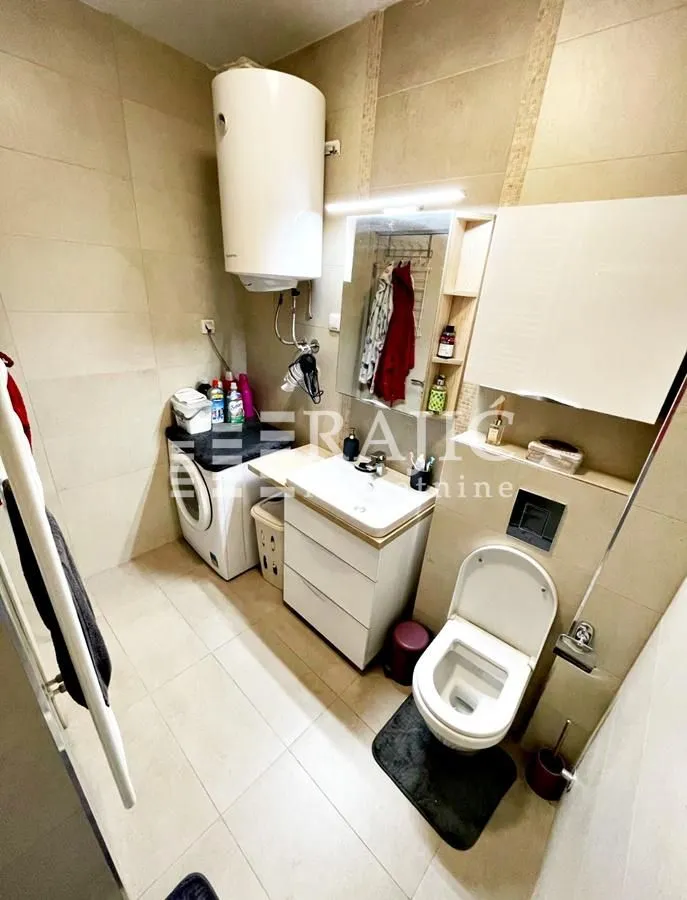 Fully equipped bathroom with sanitary fixtures, washbasin, and washing machine.