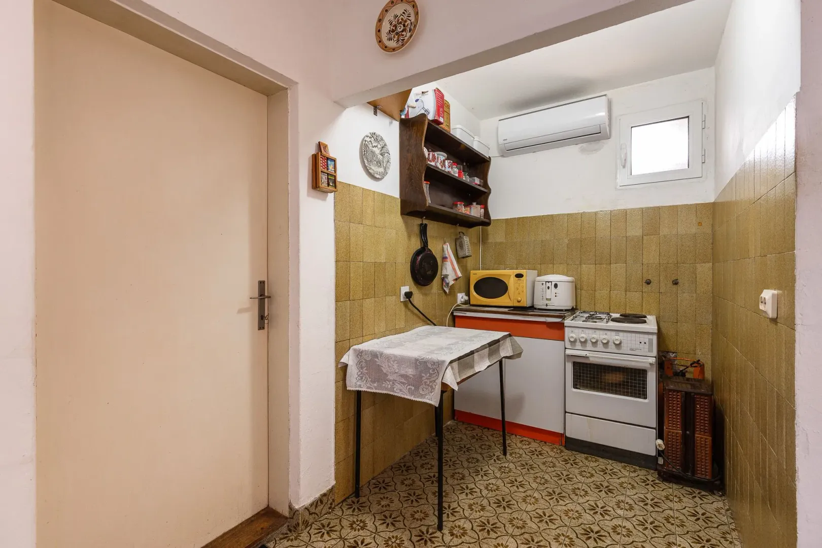 Manja kuhinja sa trpezarijskim stolom i retro elementima.