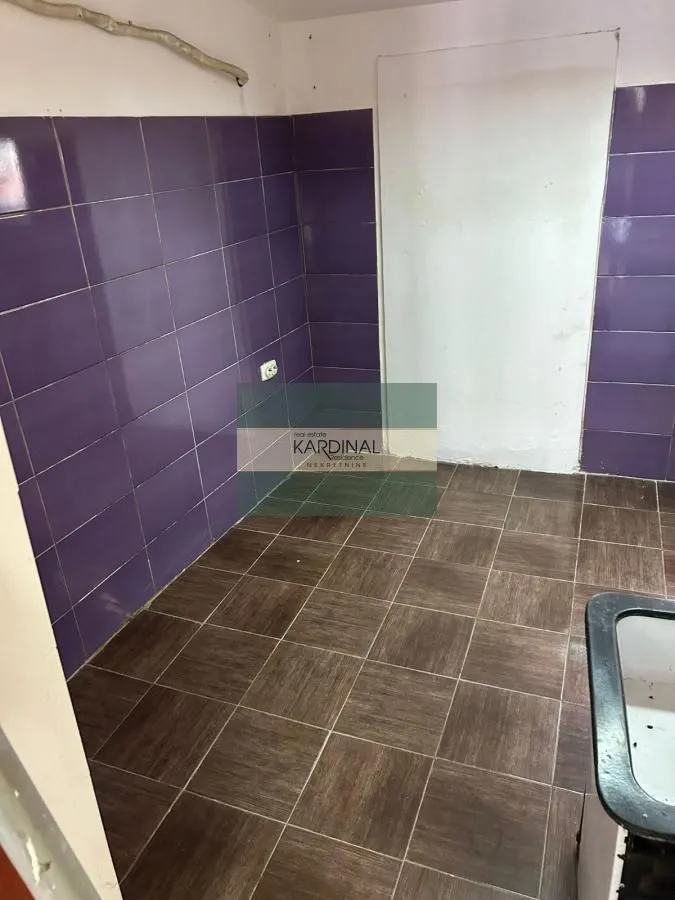 Kitchen tiled with purple wall tiles and floor tiles.