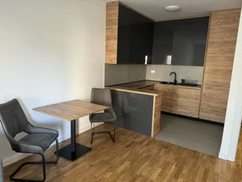 Modern kitchen with wood-look cabinets and a dining table. - image 2