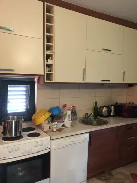 Kitchen with white and wooden cabinets, a stove, and a dishwasher. - image 16