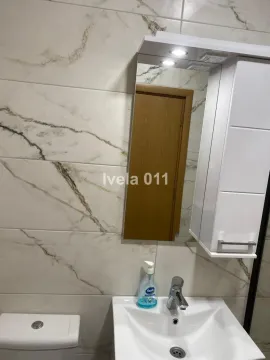 Pogled na kupatilo sa umivaonikom, ogledalom i pločicama sa dezenom mermera. - image 8