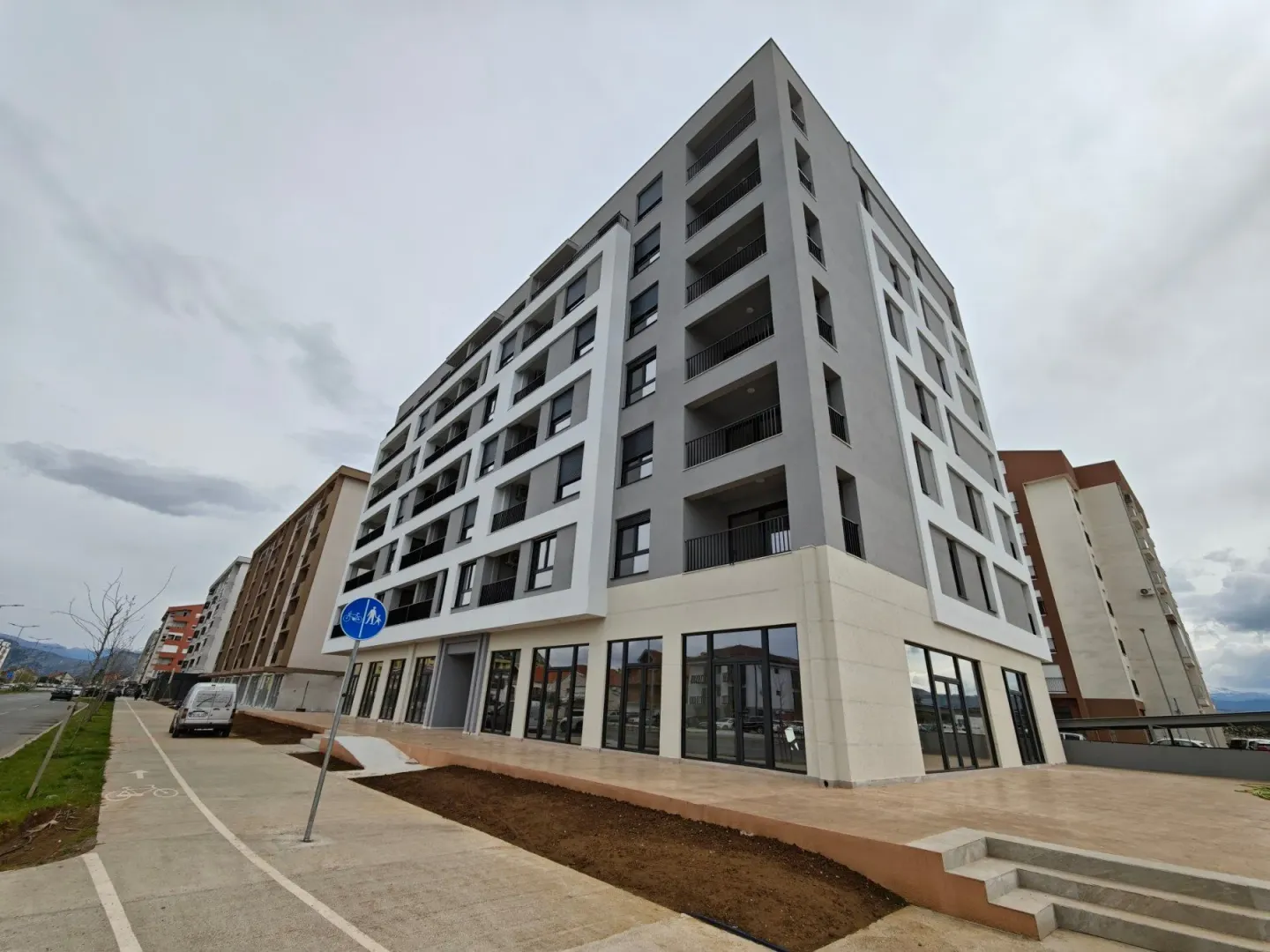 Exterior of a modern multi-family building with commercial space on the ground floor.
