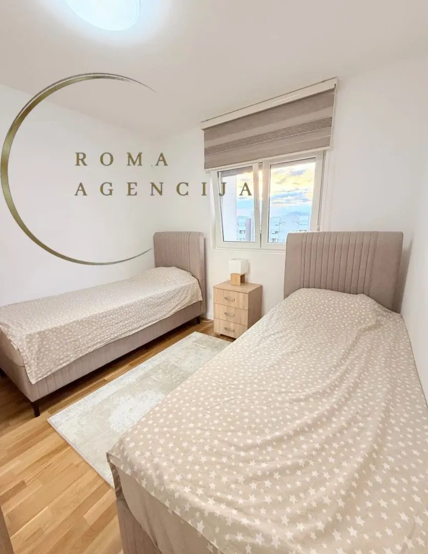 Bright bedroom with two single beds and a bedside table.