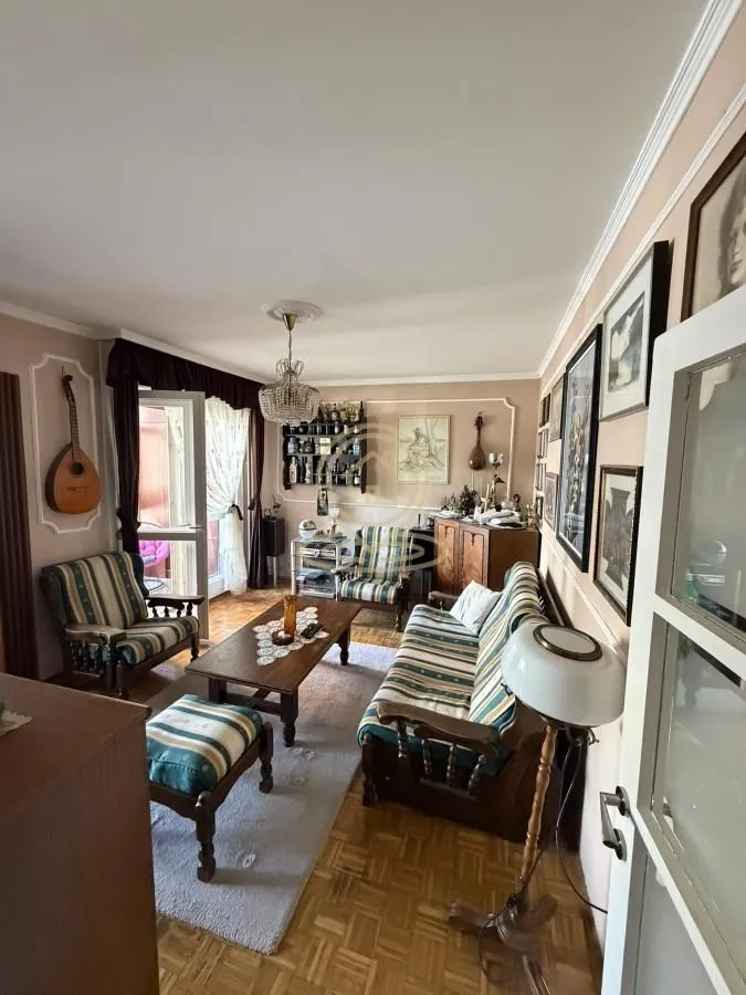 Living room with seating furniture, a coffee table, and parquet flooring.