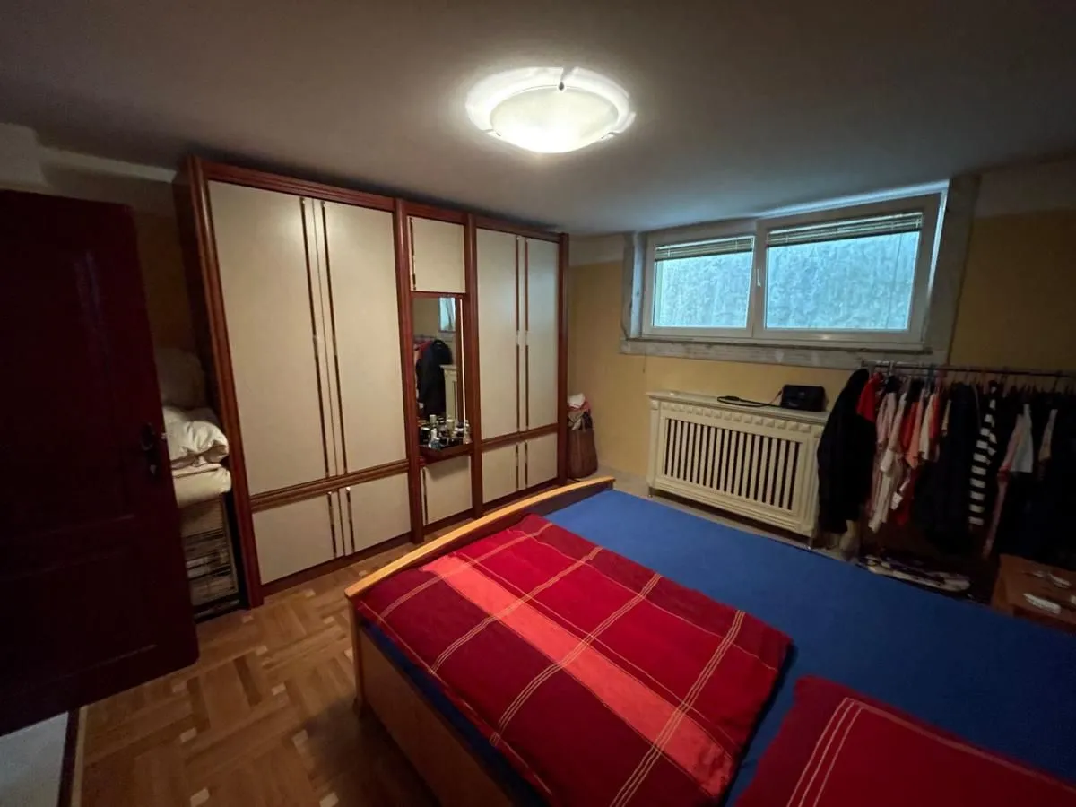 Nameštena spavaća soba sa velikim garderoberom i krevetom.