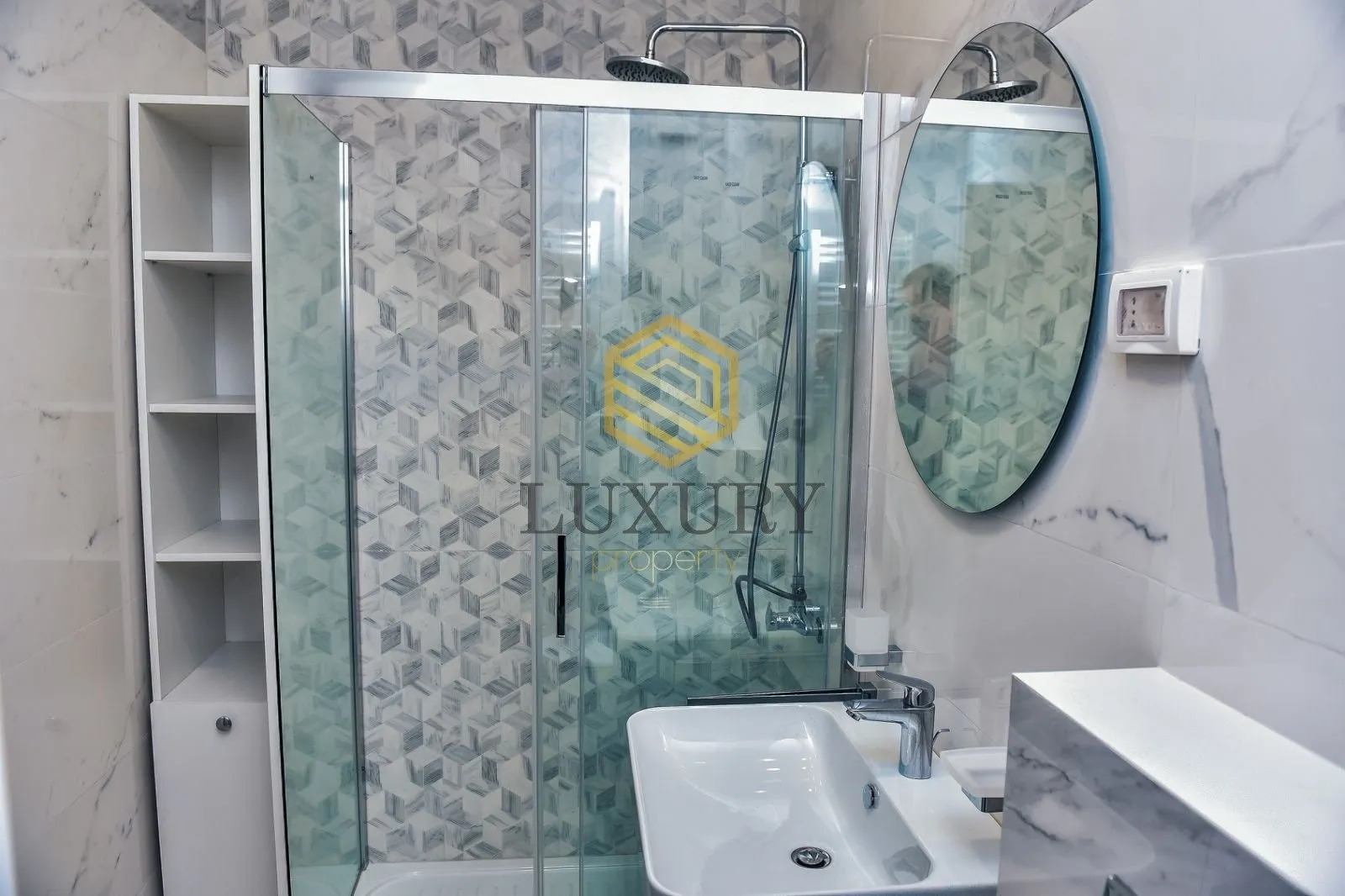 Modernly equipped bathroom with a shower cabin and washbasin.