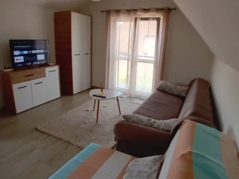 Dnevna soba sa garniturom, televizorom i izlazom na terasu. - image 3