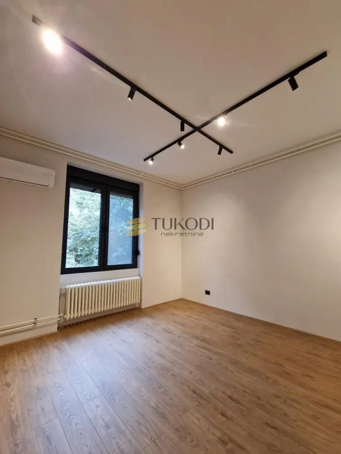 Empty room with laminate flooring and ceiling lighting.