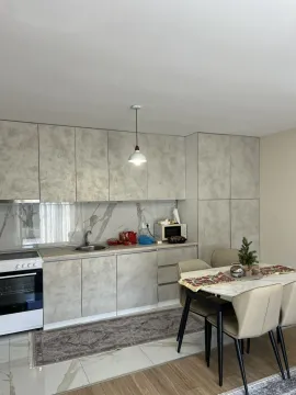 A modern kitchen with grey cabinets and a dining table. - image 15