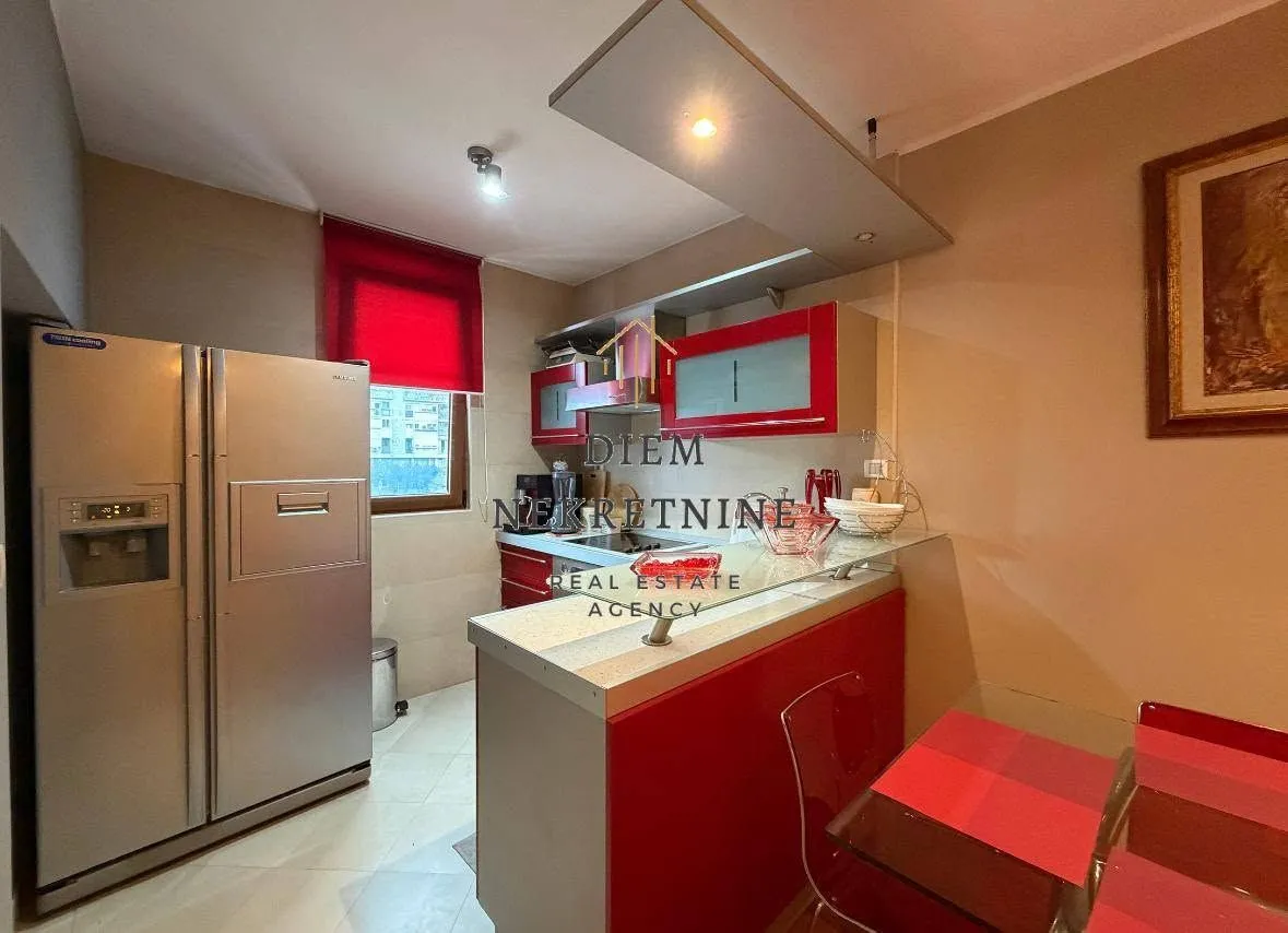 Kitchen equipped with red cabinets and a dining table.
