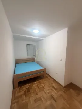 Small bedroom with a wooden bed and parquet flooring. - image 11