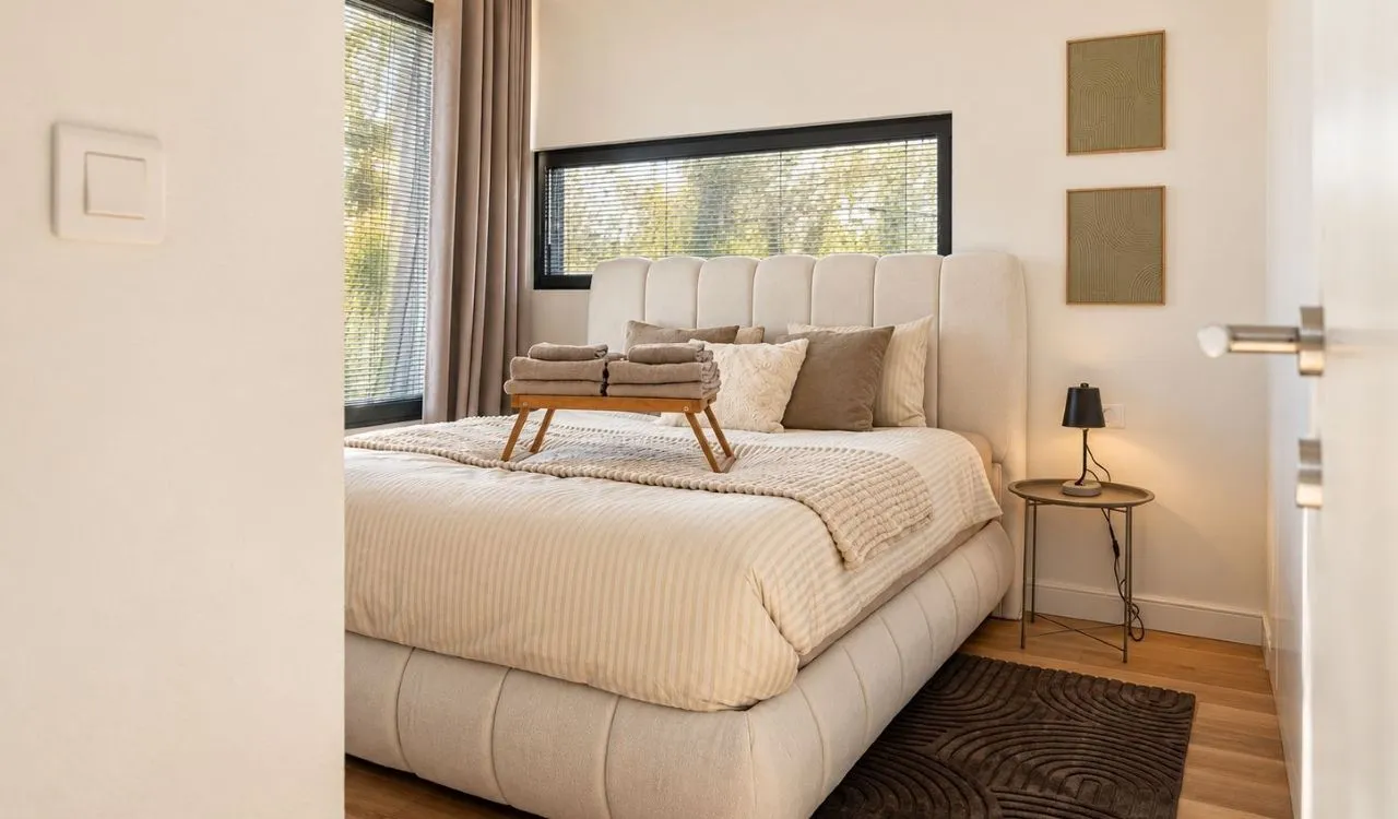 Comfortable bedroom with a double bed and windows with blinds.