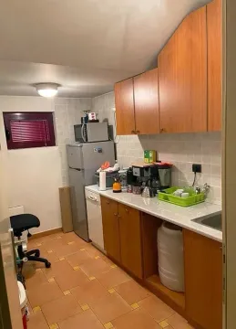 Small kitchen with wooden cabinets and appliances. - image 9