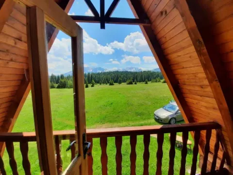 View from the terrace overlooking a green meadow, forest, and mountains. - image 2