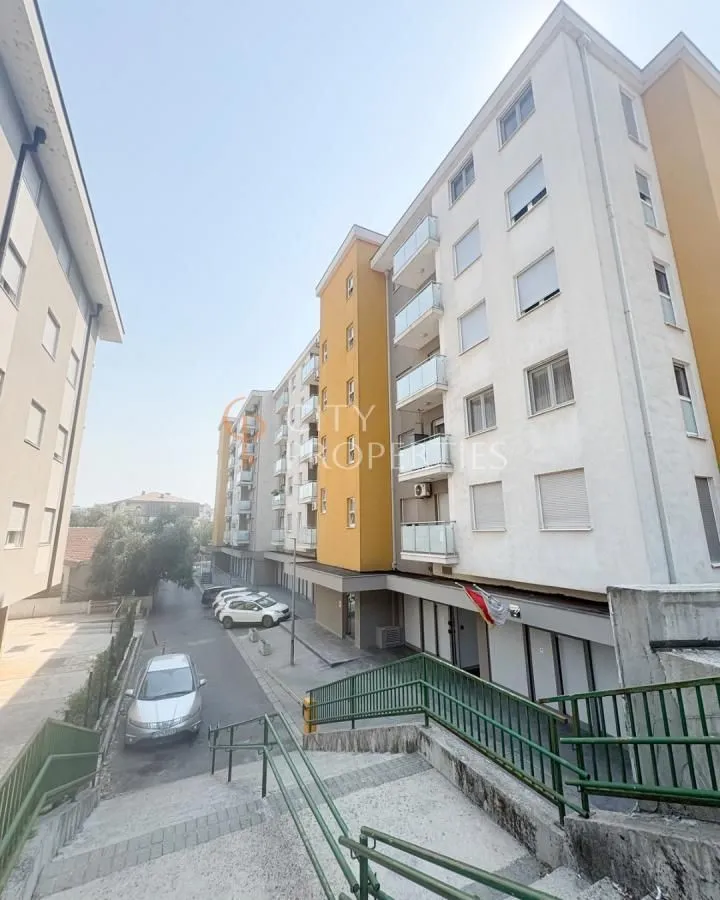 Pogled na spoljašnjost stambene zgrade i prilaz sa stepeništem.