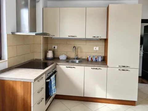 Compact kitchen with light-colored cabinetry, built-in oven, and stovetop. - image 6