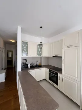 Small kitchen with cream-colored cabinets and a breakfast bar in an apartment. - image 3