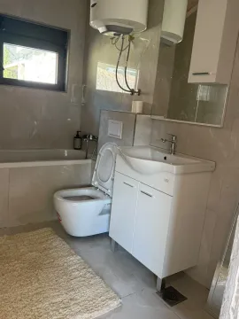 Savremeno opremljeno kupatilo sa kadom, umivaonikom i toaletom. - image 14