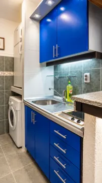 Kitchen with blue cabinets and built-in appliances. - image 4