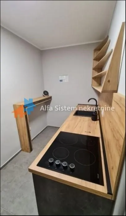 Small kitchen with built-in hob, sink, and wooden elements.