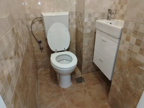 Manje kupatilo obloženo keramičkim pločicama sa WC šoljom i umivaonikom. - image 5